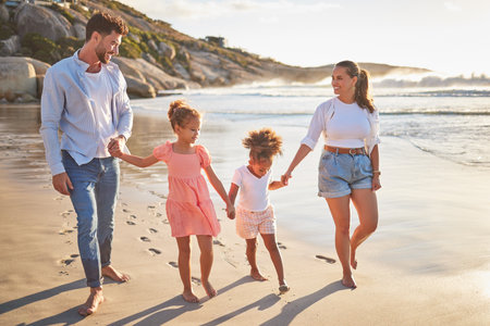 Family, children and beach of mother and man holding hands on sea sand. Summer vacation of happy fun people with kids smile in nature with relax happiness walking by the ocean water in the sunの写真素材
