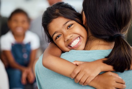 Girl, mother and bonding hug in house or home living room in trust, support or security embrace. Portrait, smile or happy child in adoption success in India, mothers day celebration or family reunionの写真素材