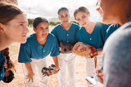Baseball, team and coach in conversation, talking and speaking about game strategy for a game. Teamwork, collaboration and coaching with women or teens listen to group leader during sport discussionの写真素材