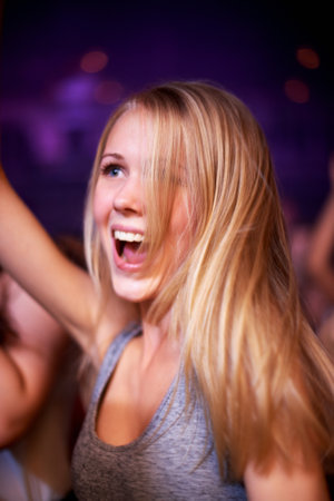This is my favourite band. A young woman dancing in a crowd at a concert.