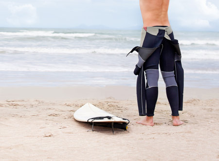 Surfing is a way of life. A young male surfer getting ready to go for a surf on a hot summers day.の写真素材