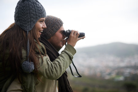 Taking in the views as the hike to the top. A young couple taking in all the scenary while enjoying a mountain hike.の写真素材