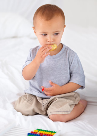 Eating a tasty cracker. A cute little boy eating a tasty cracker.の写真素材