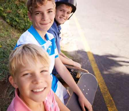 Ready to go downhill. Portrait of three young brothers enjoying a day outside skateboarding.の写真素材