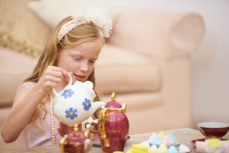 Having the perfect tea party. A cute little girl playing at having a tea party.の写真素材