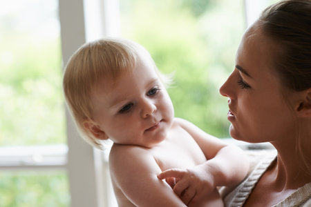 Safe in Mommys arms. A loving young mother holding her adorable baby.