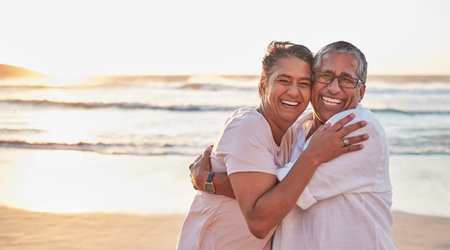 Senior couple, beach travel and hug by water of Dubai, happy on holiday for retirement and love by ocean. Portrait of elderly African man and woman hugging by sea during vacation with mockup spaceの写真素材
