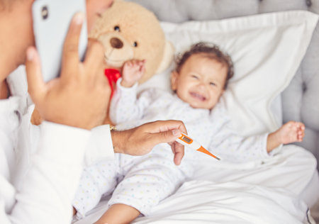 Sick child with covid or flu, mother with thermometer in hand and calling doctor for crying child....