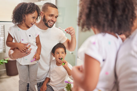 Dad, kids and brushing teeth dental healthcare, cleaning and bathroom hygiene at home. Happy father, girl and boy children learning oral wellness, fresh breath and smile for toothpaste on toothbrushの写真素材