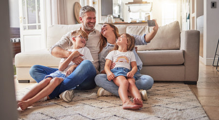 Happy, relax and selfie with family in living room for love, media and support together. Smile, support and and internet with parents and children posing for phone camera at home for social mediaの写真素材