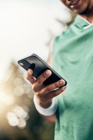 Sports, exercise and hand of man with phone to check steps, health and fitness tracker or workout support app. Tech, cardio and black runner review his marathon training progress on mobile smartphoneの写真素材