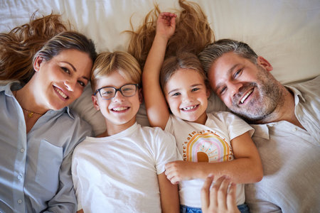Top view, family or children bonding in bedroom in house, home or hotel and parents in trust, love...