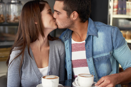 Their love knows no boundries. a young couple kissing in a cafe.の写真素材