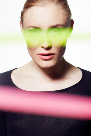 Seeing the world through neon. Headshot of stylish model highlighted with streaks of color isolated...
