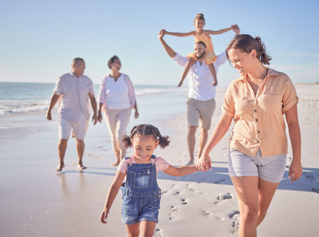 Family, mother and girl holding hands beach on summer holiday in Mexico. Footprints, memories and a happy woman with child at the ocean. Grandma, grandpa and kids with mom and dad walking on sea sandの写真素材