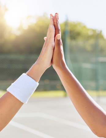 Hands, high five and people on a tennis court with motivation, success and partnership. Closeup of support, unity and diverse friends on a field for team building, training or sports match win.の写真素材