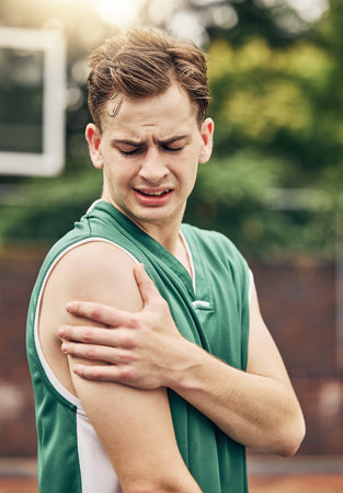 Muscle injury, basketball or sport pain and man with emergency arm accident during game on an outdoor court. Professional athlete with medical problem during training and exercise for sport matchの写真素材