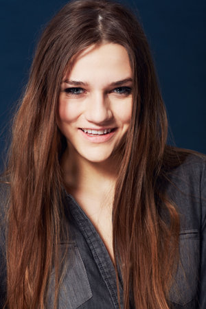 Giving you a gorgeous smile. Head and shoulders portrait of a gorgeous young woman smiling in studio.の写真素材