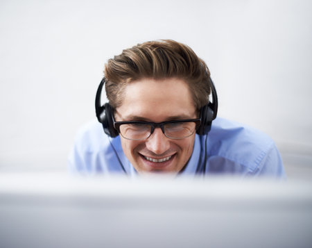 Hes making progress. A young businessman looking at his computer screen enthusiastically.の写真素材