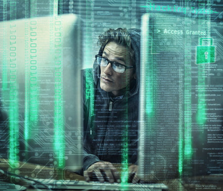 Hacking the main frame. a young man wearing hoodie while hacking into a computer.