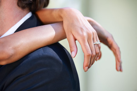 Wrapped in her love. Closeup of a brides hands wrapped around her husbands neck.の写真素材