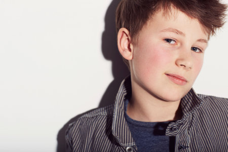 Hes got plenty of confidence. Young adolescent boy looking confident against a white background.の写真素材