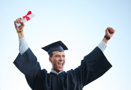 Education, success and student celebrating university graduation, cheeriing, joy and victory. Motivation, vision and man excited about educational goal accomplishment at certificate ceremony outdoorの写真素材
