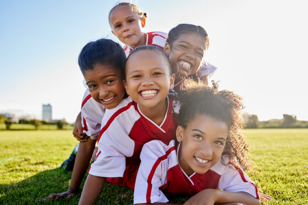 Girl, soccer and team portrait smile on grass together in sports field for kids game in the outdoors. Happy female children smiling in fun teamwork success for football sport, fitness and exerciseの写真素材