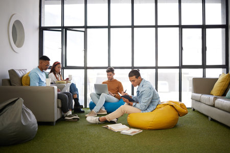 Relax, education and learning with students in room for university, internet and knowledge. College, online and support with friends studying with books and laptop for school, community and projectの写真素材