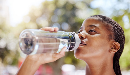 Fitness girl drink bottle of water to refresh after sports exercise, marathon training run or cardio...