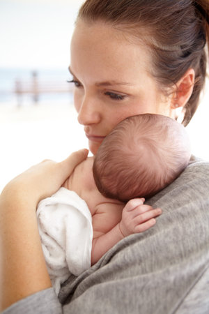 Tender love. a young mother holding her newborn baby girl in her arms.
