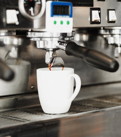 Filling with freshness. freshly brewed coffee pouring out of a coffee machine into a mug.の写真素材