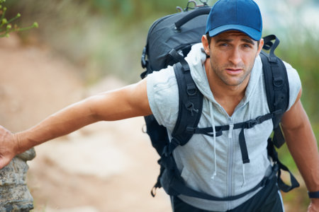 He loves the outdoors. Handsome young hiker looking up at the camera.の写真素材