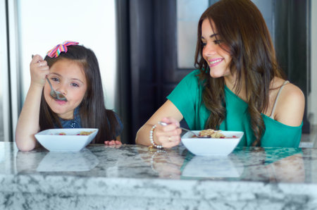 Breakfast is the most important meal of the day. Mother and daughter enjoying breakfast together...