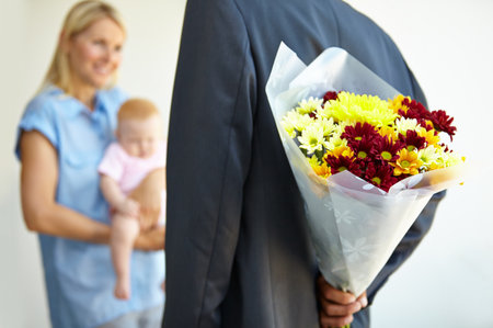 He didnt forget their anniversary. a man surprising his wife with flowers.の写真素材