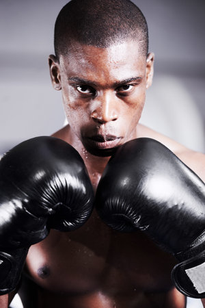 Lets get started. An african american boxer with his gloves up and gum guard in.