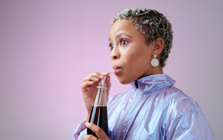 Cola, wow and black woman with surprise from drink in bottle against a pink mockup studio background. Girl model shocked and happy while drinking cold summer beverage with a straw and mock up spaceの写真素材