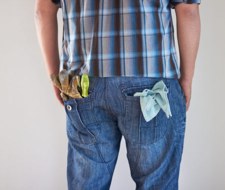 Handyman. Rear view of a handyman with gloves and a cloth stuffed into his jeans.
