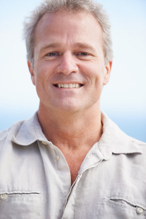 Enjoying some fresh sea air. Head and shoulders portrait of a mature man smiling happily at the...