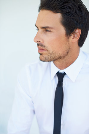 Thinking about business strategies. A handsome young businessman looking away.の写真素材