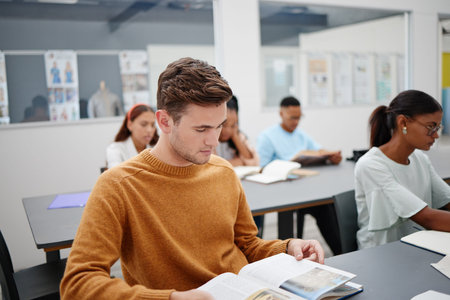 Education, university student and man reading book in classroom, studying or assignment research....