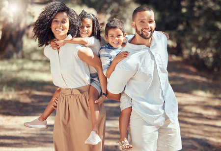 Portrait of happy family bonding in a park, having fun and being playful on peaceful walk in nature together. Relaxed parents enjoy time with kids and moments of parenthood while showing affectionの写真素材