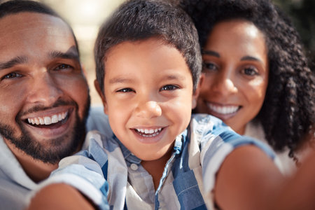 Happy, smile portrait of family taking selfie outdoors, having fun laughing and bonding. Love, happy family and caring parents enjoy free time with their playful son, laughing and showing affectionの写真素材