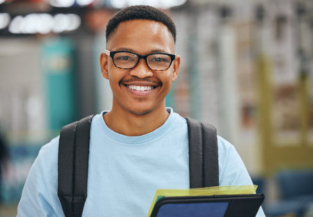 Black student, education and man with smile in library, college or university with books for...