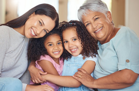 Portrait, smile and happy family on mothers day with grandmother, mom and girl siblings hugging at home. Mama, children and elderly woman love relaxing, bonding and enjoying quality time togetherの写真素材