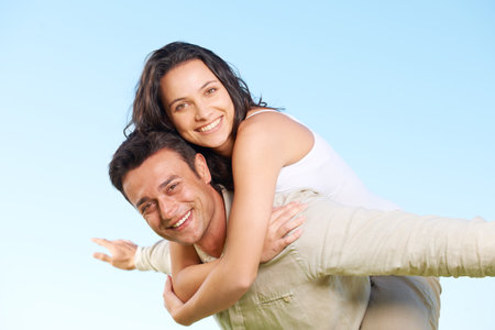 Having fun together. An attractive young couple being playful outside.の写真素材