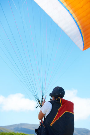 Why walk when you can fly. a man paragliding on a sunny day.の写真素材