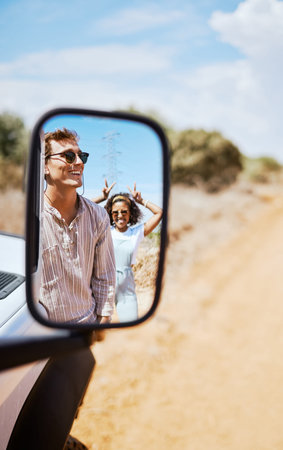 Couple on road trip, smile in car mirror reflection and happy smile with love on desert holiday road trip drive in South Africa. Summer vacation in the wild, diverse male and female friends with funの写真素材