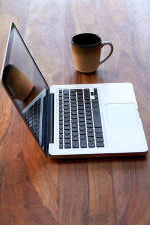 Working essentials. a laptop and coffee mug on a table.