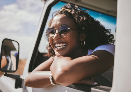 Black woman, happy road trip and car travel of a person sitting in a motor ready for a summer vacation. Transport traveling of a female from Jamaica with happiness and smile feeling fun in the sunの写真素材